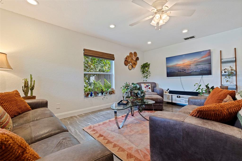 A living room features leather sofas, a glass coffee table, and a wall-mounted television — 2940 47TH AVENUE S, ST PETERSBURG, FL