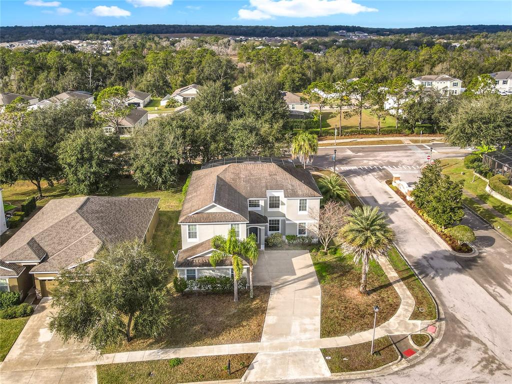 An aerial view shows a two-story house with a driveway and a screened-in pool area — 4764 COPPOLA DRIVE, MOUNT DORA, FL