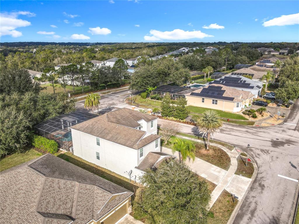 An aerial view shows a two-story house with a pool enclosure in a suburban neighborhood — 4764 COPPOLA DRIVE, MOUNT DORA, FL