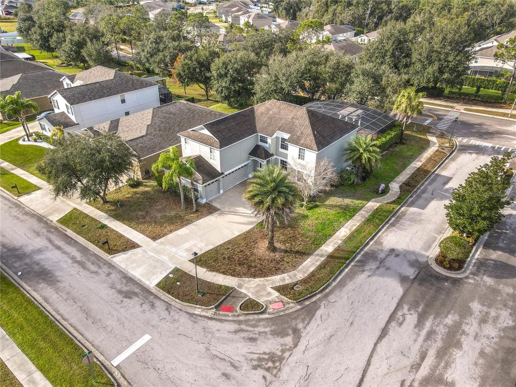 An aerial view of a two-story house on a corner lot with a screened pool — 4764 COPPOLA DRIVE, MOUNT DORA, FL