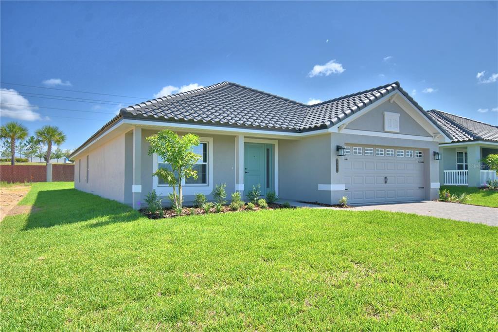 A single-story house with a gray exterior, a tiled roof, and a two-car garage — 4467 JULIANA LAKE DRIVE, AUBURNDALE, FL