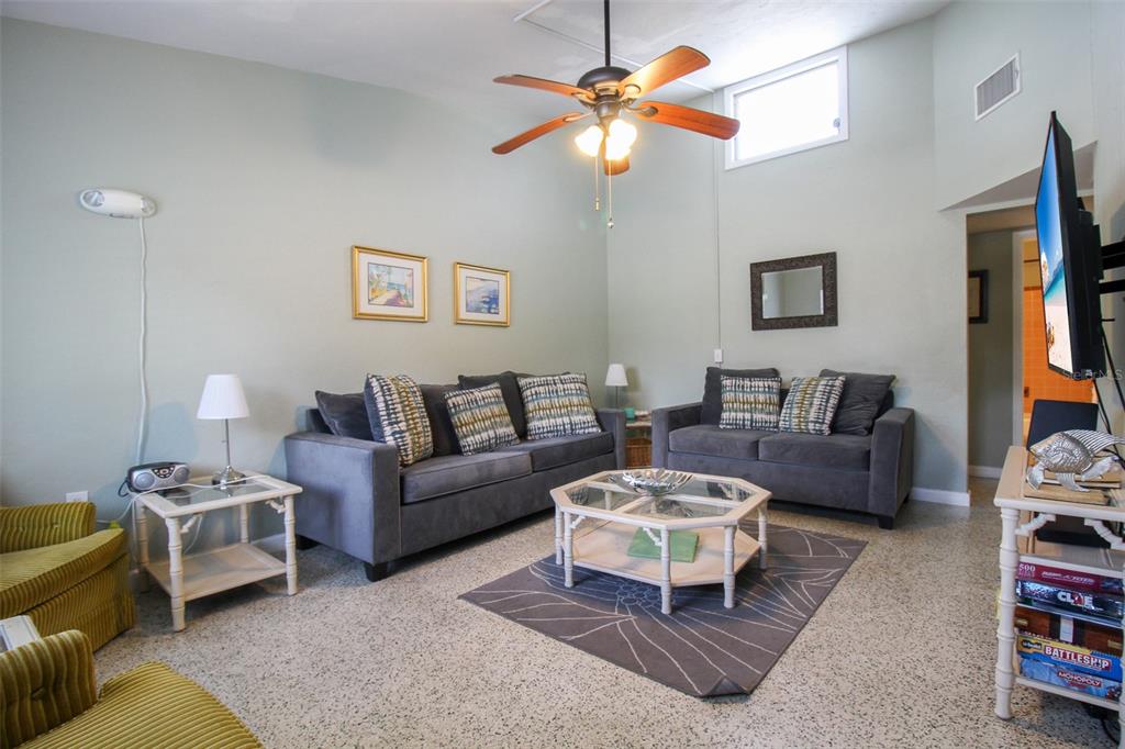 A living room features two gray sofas, a glass coffee table, and a ceiling fan — 606 HARBOR DRIVE S, VENICE, FL