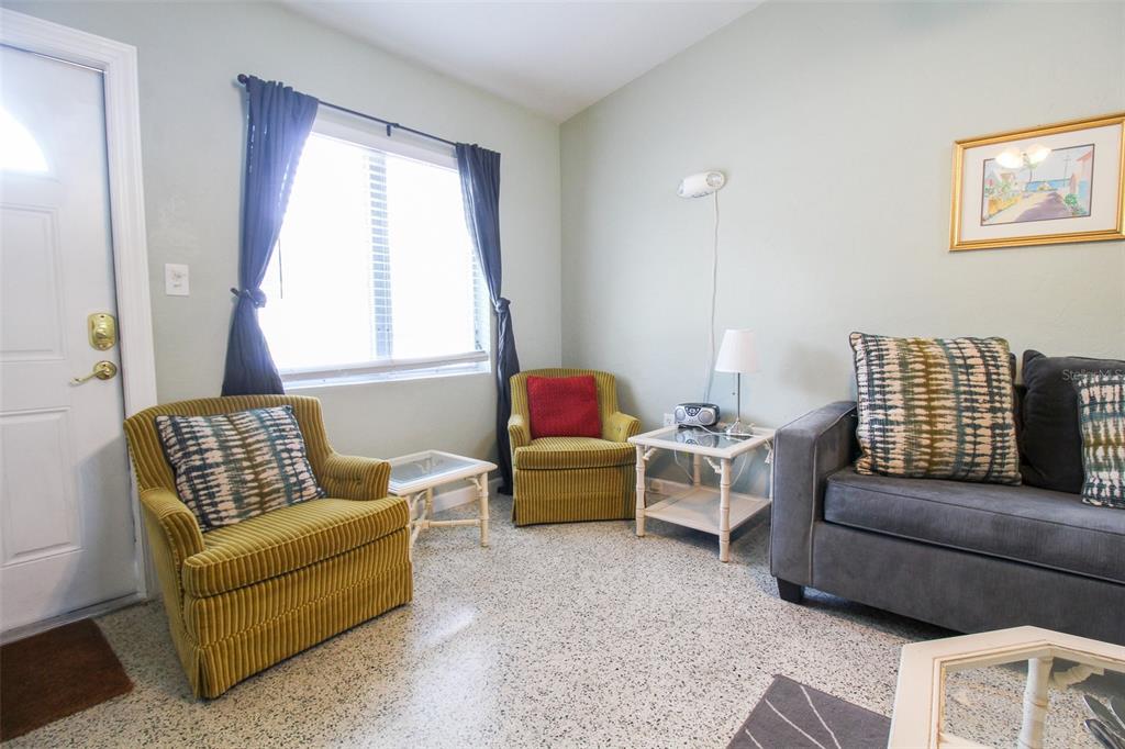 A living room features two yellow armchairs, a gray sofa, and a window with curtains — 606 HARBOR DRIVE S, VENICE, FL