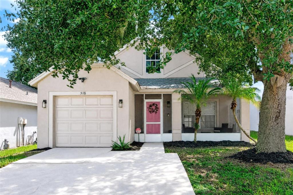 A single-story house with a beige exterior, a pink front door, and a one-car garage — 518 SUMMER SAILS DRIVE, VALRICO, FL