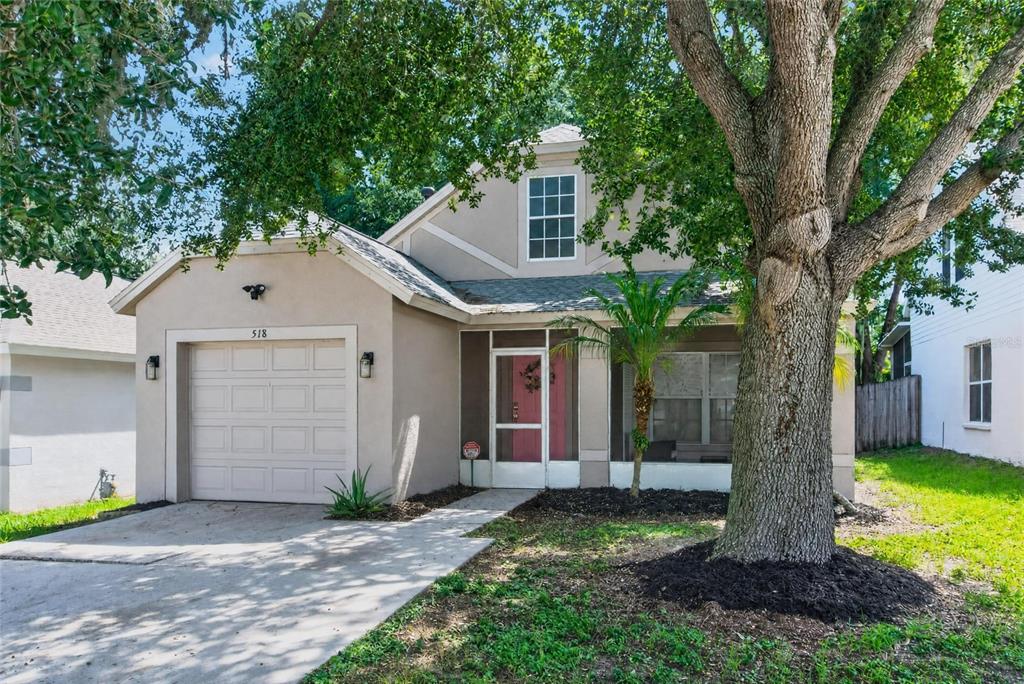 A tan two-story house with a single-car garage, a screened entryway, and a large tree — 518 SUMMER SAILS DRIVE, VALRICO, FL