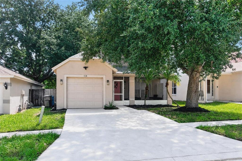 A single-story house with a beige exterior, a one-car garage, and a screened-in front porch — 518 SUMMER SAILS DRIVE, VALRICO, FL