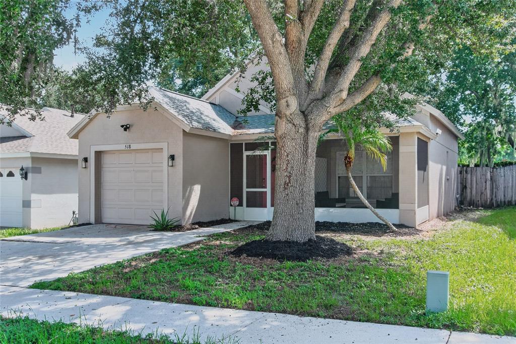 A single-story house with a beige exterior, a one-car garage, and a screened-in front porch — 518 SUMMER SAILS DRIVE, VALRICO, FL
