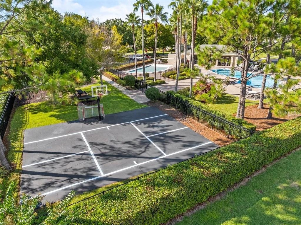 An aerial view of a basketball court next to a swimming pool and green landscaping — 125 COSTA LOOP, AUBURNDALE, FL