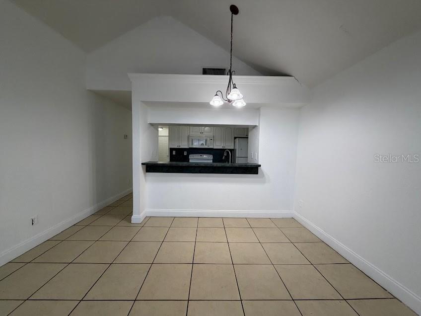 A dining area with tile floors and a pass-through opening to the kitchen — 2718 RIO GRANDE TRAIL UNIT 2718, KISSIMMEE, FL