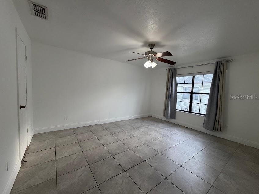 A bedroom with white walls, tile flooring, a ceiling fan, and a window with curtains — 2718 RIO GRANDE TRAIL UNIT 2718, KISSIMMEE, FL