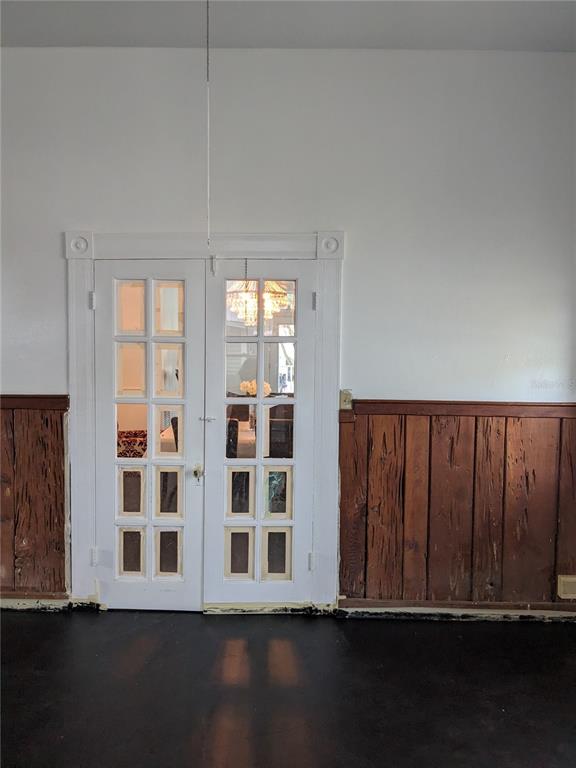 An entryway features a staircase with black treads, a teal cabinet, and a crystal chandelier — 495 E PARKER STREET, BARTOW, FL