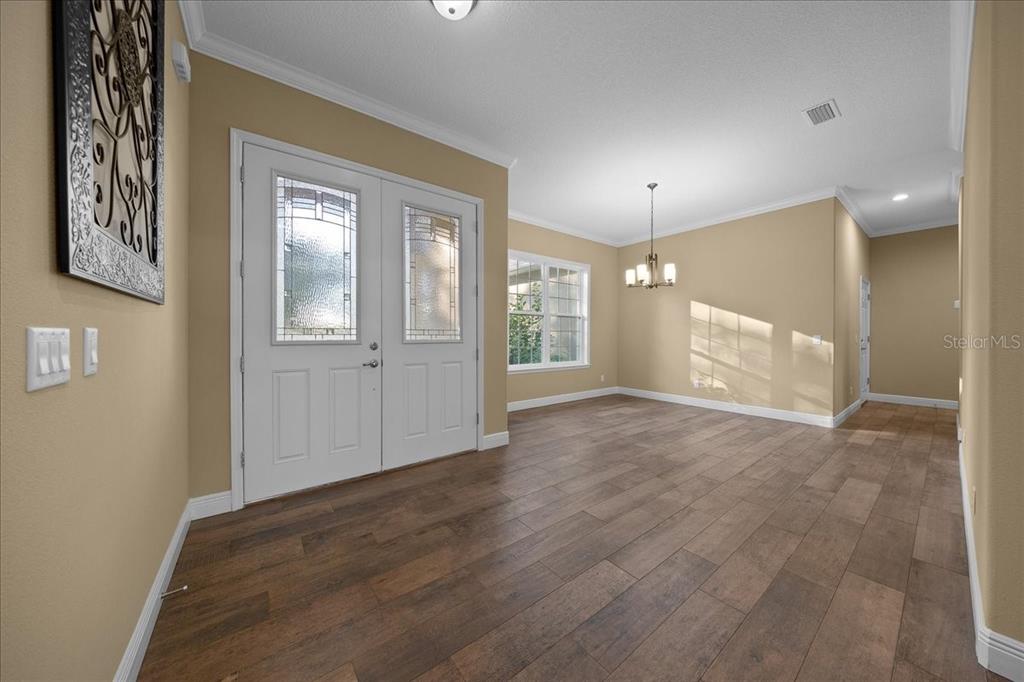 An entryway with wood-look flooring, tan walls, and a white double front door — 2087 N ANNAPOLIS AVENUE, HERNANDO, FL