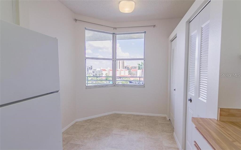 A kitchen nook with tile flooring, a bay window, and white louvered closet doors — 7902 SAILBOAT KEY BOULEVARD S UNIT 402, SOUTH PASADENA, FL