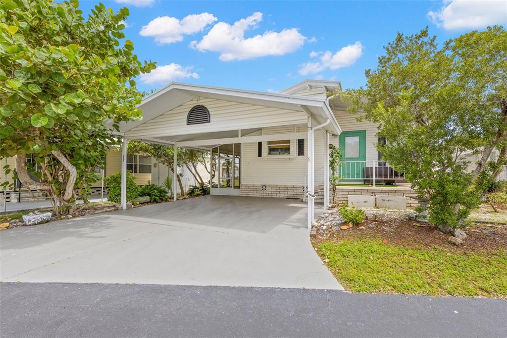 A single-story house with a white exterior, a carport, and a green front door — 357 MOUNT SAXON AVENUE NE UNIT 323, ST PETERSBURG, FL