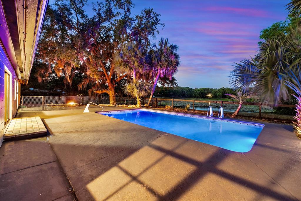 An open-concept living and dining area features tile flooring, a fireplace, and a kitchen island — 36245 E SPRING LAKE BOULEVARD, FRUITLAND PARK, FL