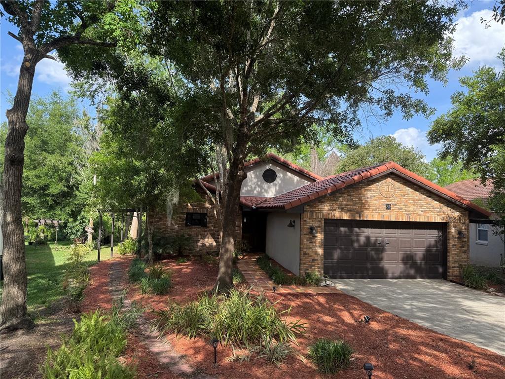 A single-story brick house with a brown tile roof and a two-car garage — 39 FOREST LANE, EUSTIS, FL