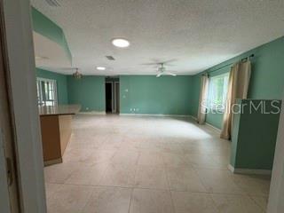 An open-concept living area features light green walls, tile flooring, and a kitchen island — 19279 SW 96TH LOOP, DUNNELLON, FL
