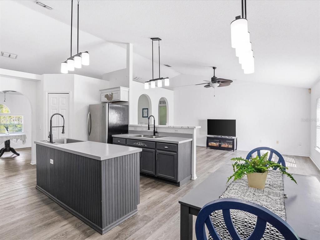 A kitchen with dark gray cabinetry and a matching island features white countertops and lighting — 3002 MONCRIEF AVE, NORTH PORT, FL