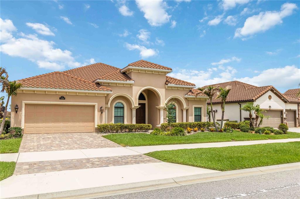A single-story stucco house with a tile roof, arched entry, and an attached garage — 7966 WYNDHAM DRIVE, MELBOURNE, FL