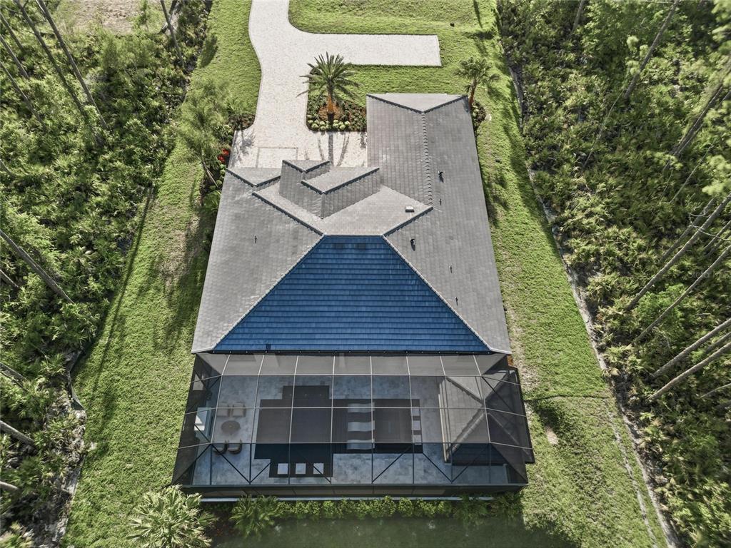 An aerial view shows a house with a blue-tiled roof and a screened-in pool area — 461 N TYMBER CREEK ROAD, ORMOND BEACH, FL