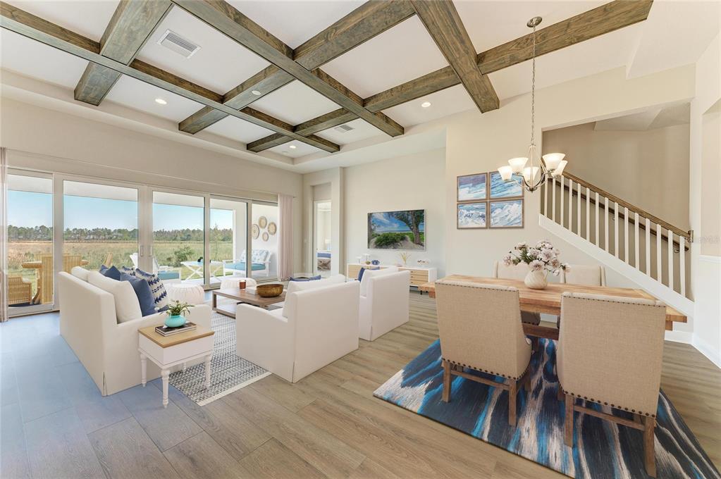 An open-concept living and dining area features a coffered ceiling with wood beams and stairs — 2058 ARCHING BRANCH DRIVE, ZEPHYRHILLS, FL