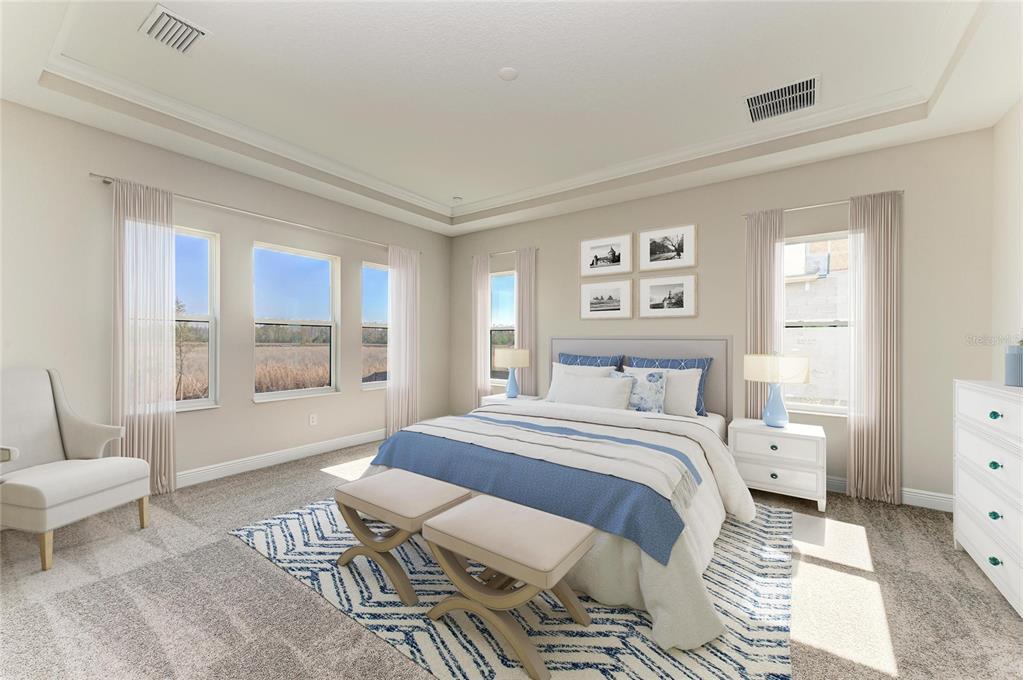 A bedroom features a king bed, two benches, neutral walls, and large windows with views — 2058 ARCHING BRANCH DRIVE, ZEPHYRHILLS, FL