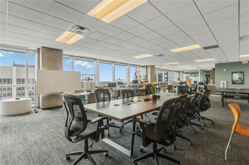 A modern office conference room features a long table, ergonomic chairs, and floor-to-ceiling windows — 189 S ORANGE AVENUE UNIT 1930S, ORLANDO, FL