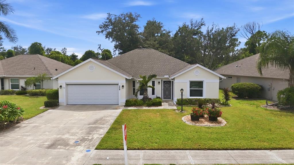 A single-story suburban house with a two-car garage, light-colored siding, and a landscaped front yard — 259 PARK FOREST BOULEVARD, ENGLEWOOD, FL