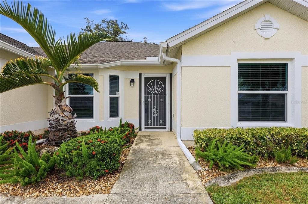 A single-story house with a beige stucco exterior, a palm tree, and a landscaped yard — 259 PARK FOREST BOULEVARD, ENGLEWOOD, FL