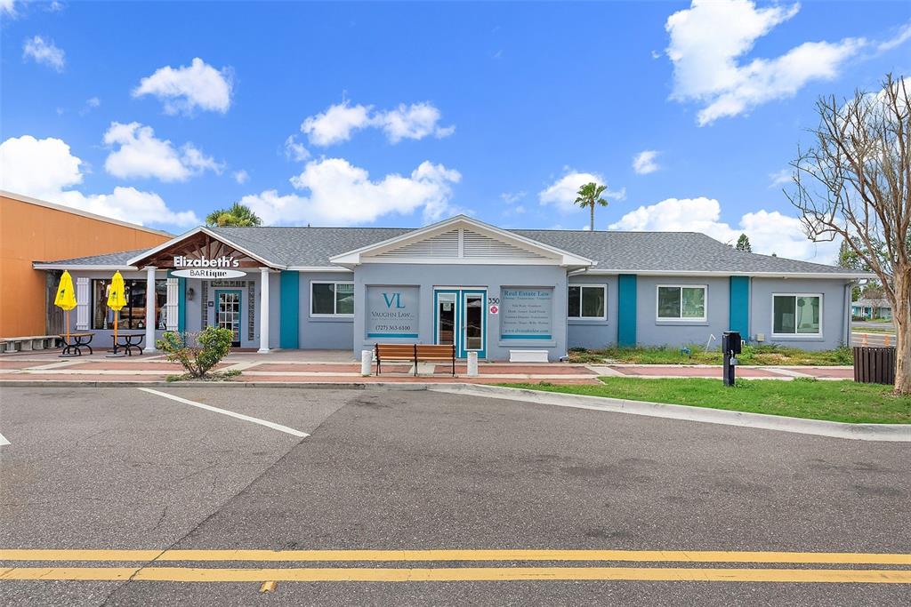 A single-story commercial building with a gray facade, blue accents, and two separate business entrances — 350 COREY AVENUE, ST PETE BEACH, FL