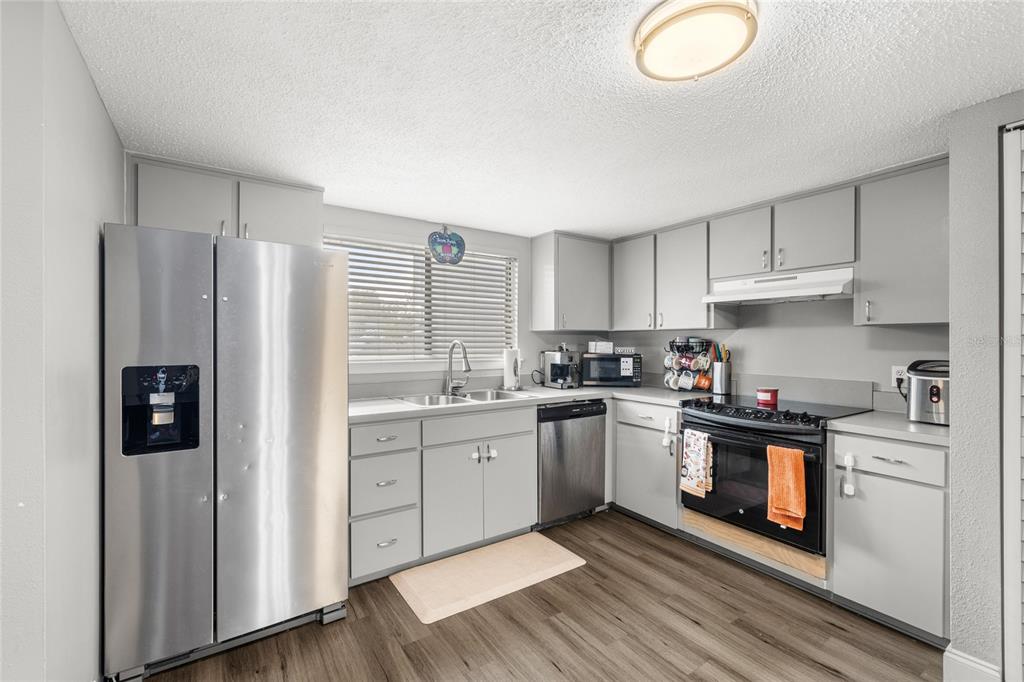 A kitchen with grey cabinets, stainless steel appliances, and wood-look flooring — 707 SAINT MATTHEW CIRCLE, ALTAMONTE SPRINGS, FL