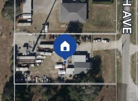 This aerial view shows a rectangular lot with several vehicles and structures — 460 NW 68TH AVENUE, OCALA, FL