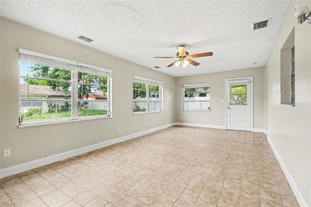 An empty bedroom features beige walls, tan carpeting, two windows, and white louvered closet doors — 140 GUAYMAS DRIVE, KISSIMMEE, FL