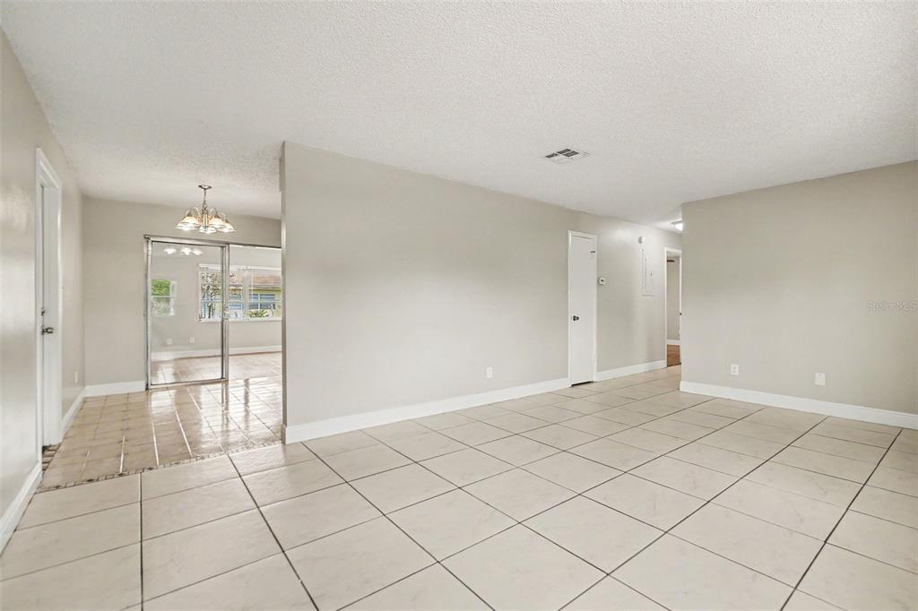 A spacious room features beige tile flooring, a ceiling fan, and an attached bathroom — 140 GUAYMAS DRIVE, KISSIMMEE, FL