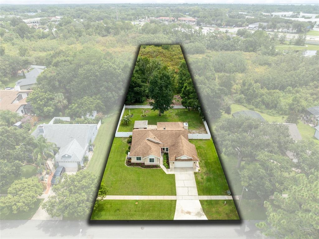 An aerial view shows a single-story house with a brown roof and a fenced backyard — 633 PUGH STREET, LAKE MARY, FL
