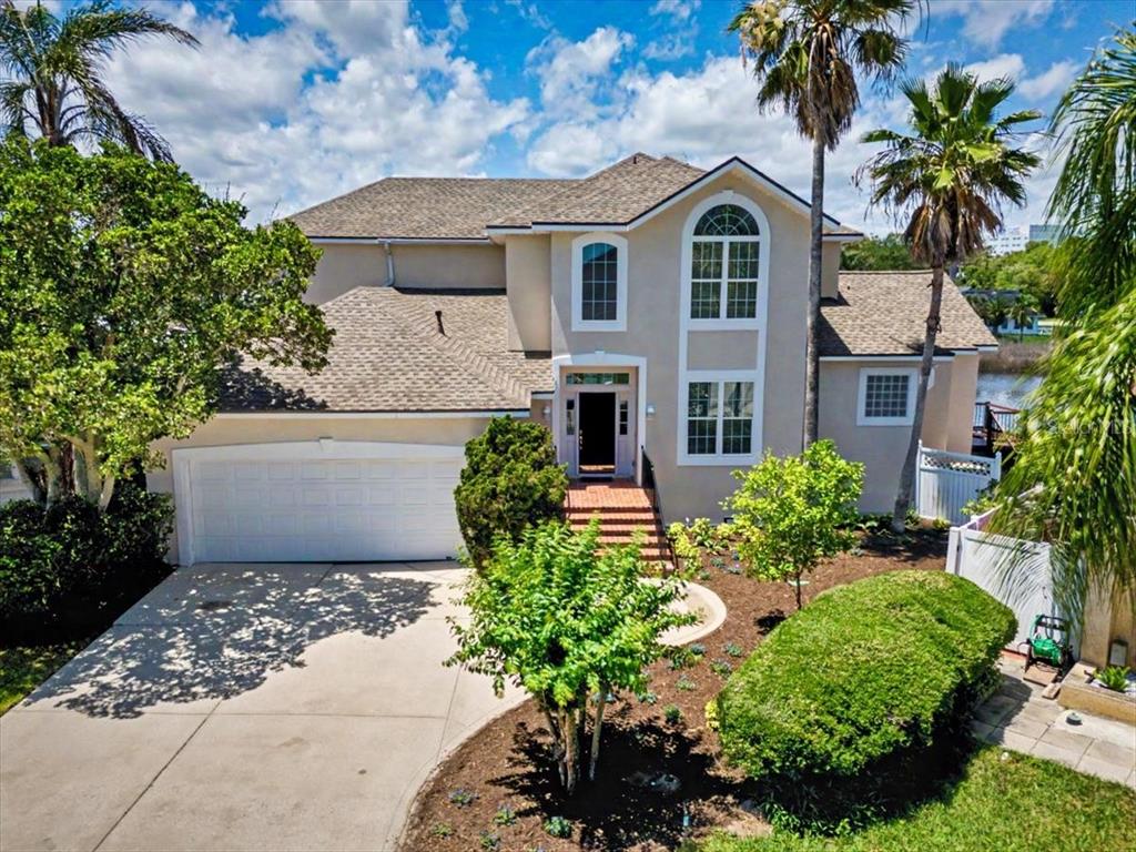A two-story suburban house with a tan exterior, a two-car garage, and palm trees — 4422 TIDEVIEW DRIVE, JACKSONVILLE, FL