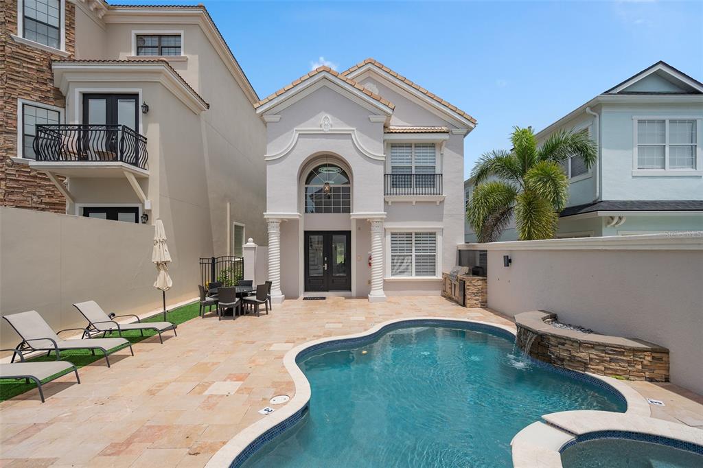 A two-story house with a gray stucco exterior, a brown garage door, and four balconies — 1402 TITIAN COURT, REUNION, FL