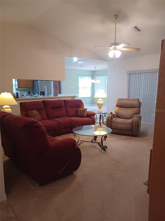 A living room features a red sofa, a tan recliner, and a glass coffee table — 19199 SW 92ND LOOP, DUNNELLON, FL