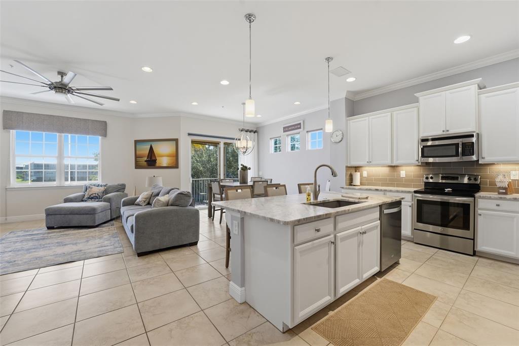 An open-concept kitchen with a center island flows into a living area and dining space — 10311 LANDS END CIRCLE UNIT 13, PLACIDA, FL