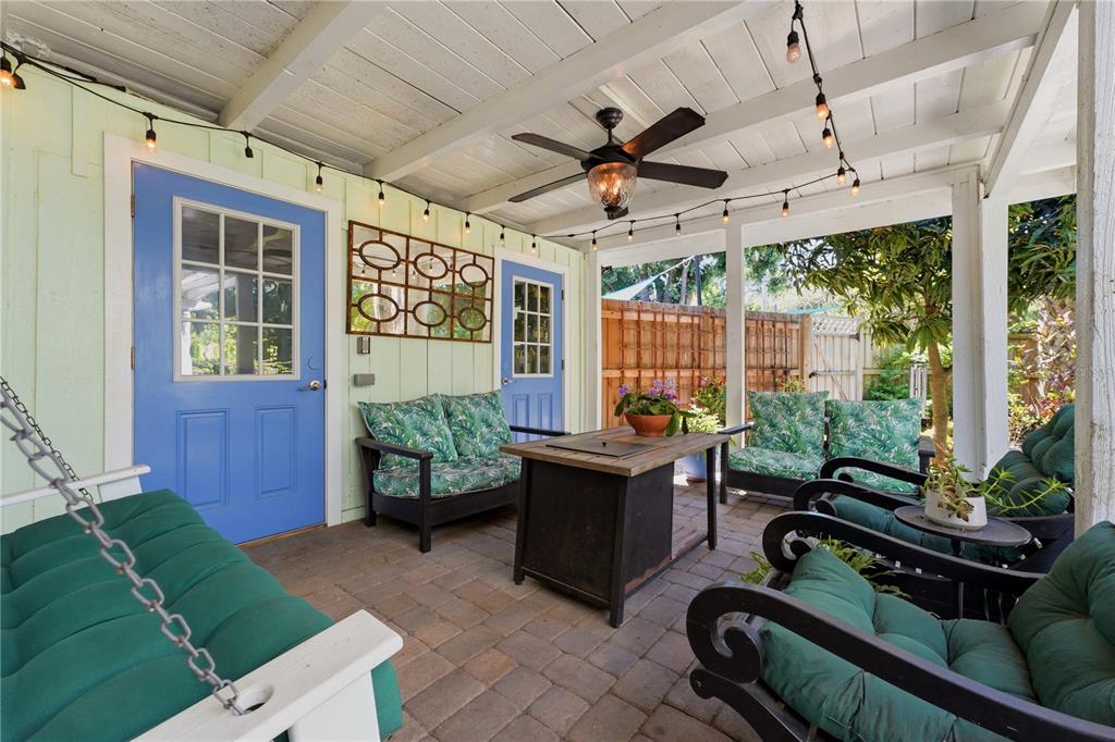 A covered patio features a brick floor, a ceiling fan, string lights, and outdoor furniture — 3424 OLD OAK DRIVE, SARASOTA, FL