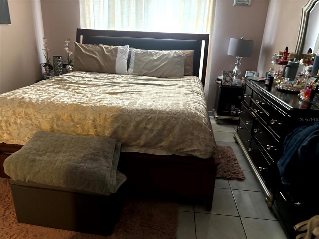 A bedroom features a dark wood bed frame, a patterned gold comforter, and a dresser — 1312 FOXBORO DR., BRANDON, FL