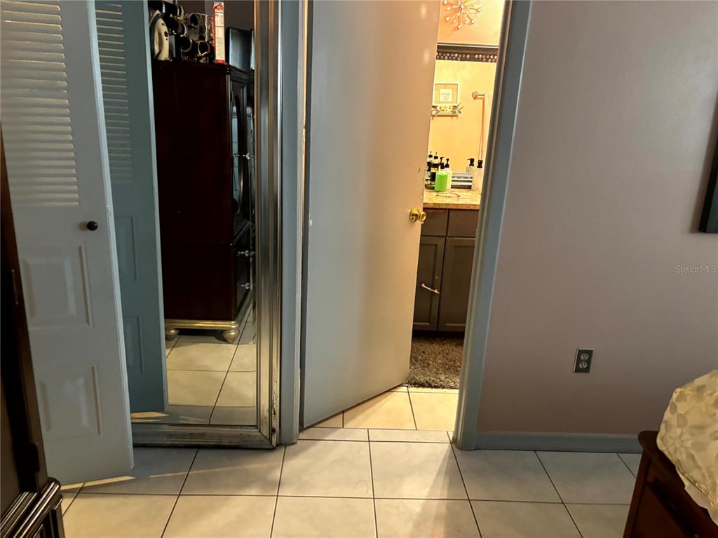 A tiled bedroom floor leads to a doorway opening into a bathroom with a vanity — 1312 FOXBORO DR., BRANDON, FL