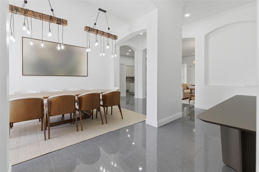 A dining room features two rustic wooden pendant lights, a long table, and tiled floors — 12513 SCARLETT SAGE COURT, WINTER GARDEN, FL