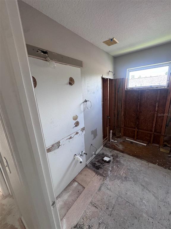 A bathroom undergoing renovation with exposed wall studs, plumbing pipes, and a subfloor — 1734 LADY PALM COURT, NEW PORT RICHEY, FL