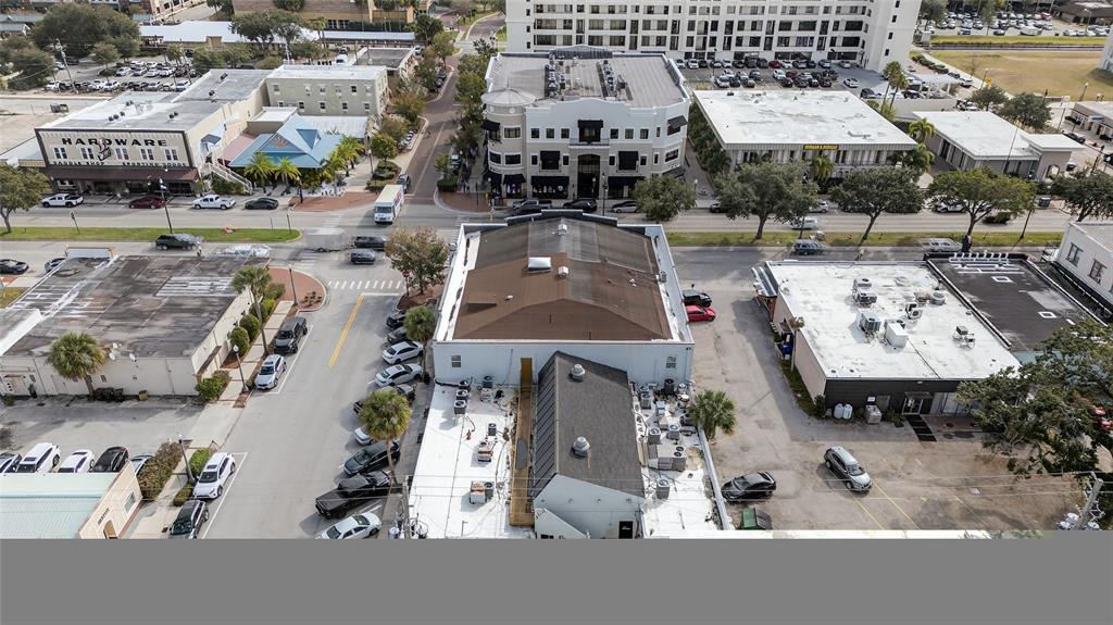 An aerial view shows a commercial building with a brown roof surrounded by parking lots — 219 BROADWAY, KISSIMMEE, FL