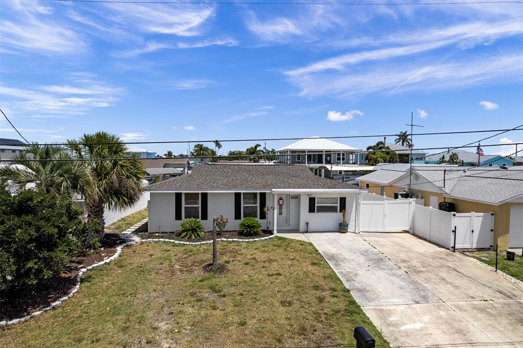 A single-story house with a gray roof, white siding, and a concrete driveway — 13804 MALCOLM AVENUE, HUDSON, FL