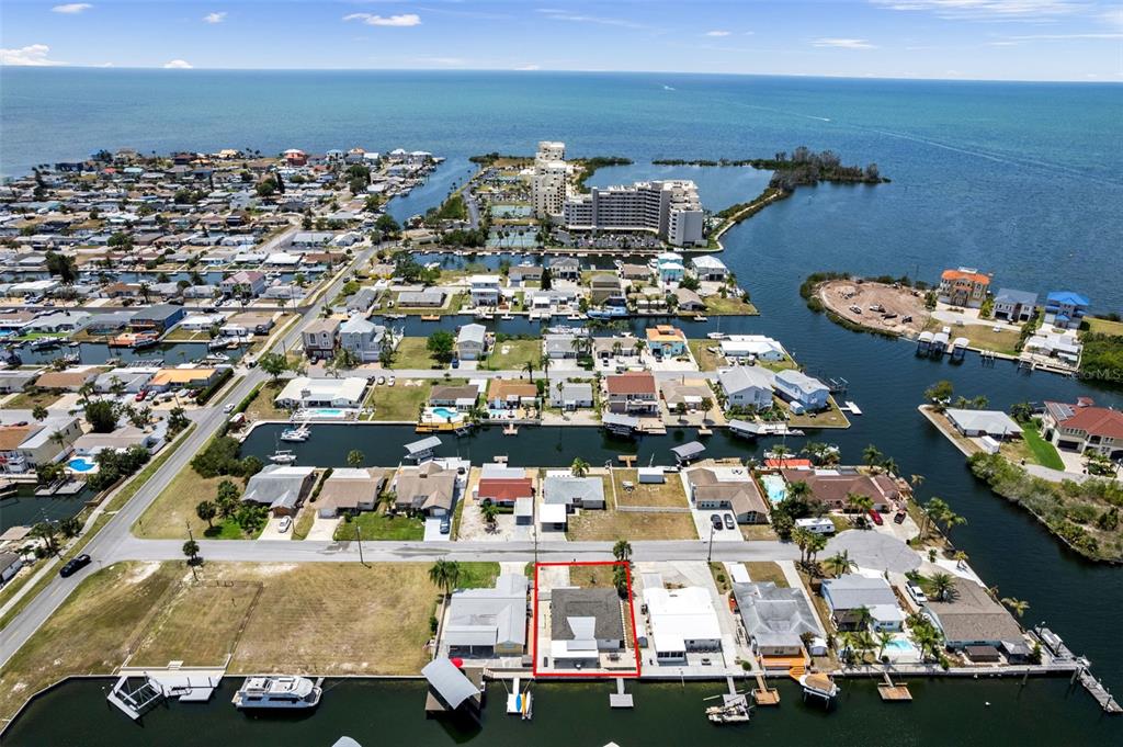 An aerial view shows a waterfront house outlined in red along a canal — 13804 MALCOLM AVENUE, HUDSON, FL