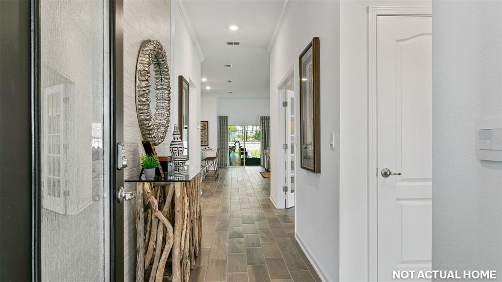 This is a rendering of a home entryway featuring a console table and tiled hallway — 63 HARDWOOD TRAIL, PALM COAST, FL