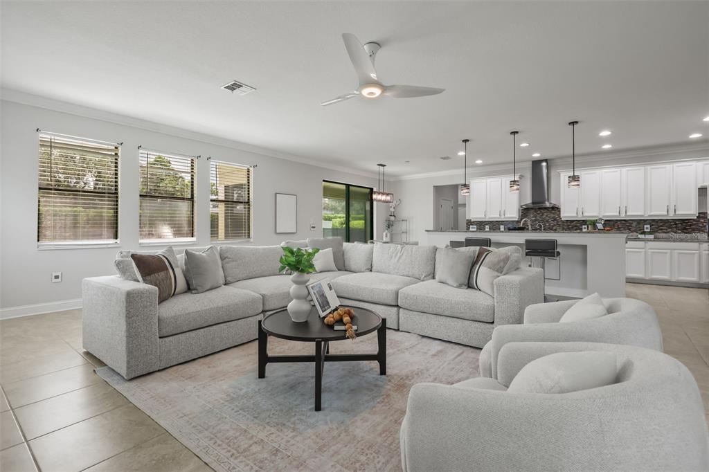 A living room features white sofas, blue accent chairs, and a long built-in wall cabinet — 17112 GUILFORD COURT, ORLANDO, FL