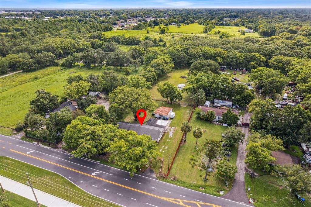 An aerial view shows a house with a red map pin located beside a road — 1001 OCOEE APOPKA ROAD, OCOEE, FL